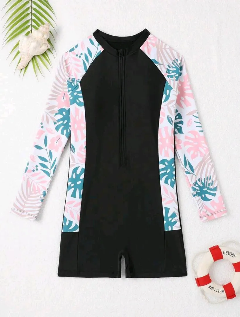 Traje de baño enterizo, negro con estampado de hojas celeste y rosa a los costados con fondo blanco